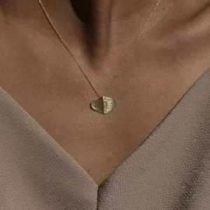 seelenanker-halskette-gingko-blatt Frau, die eine goldene Halskette mit Gingkoblatt Anhänger trägt