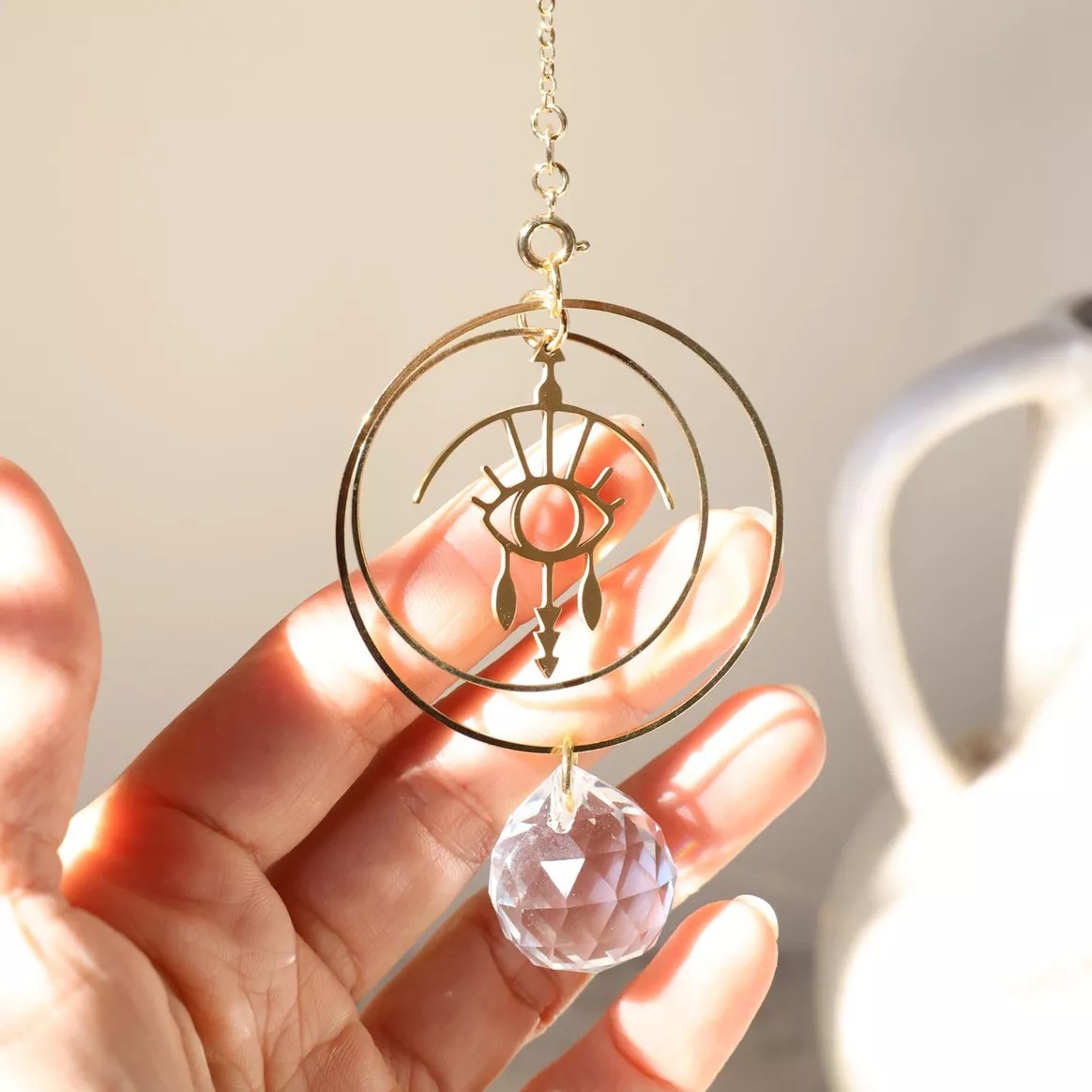 rayonne-suncatcher-wonder-2 Suncatcher aus Kristall mit Schützendes-Auge-Symbol aus Messing